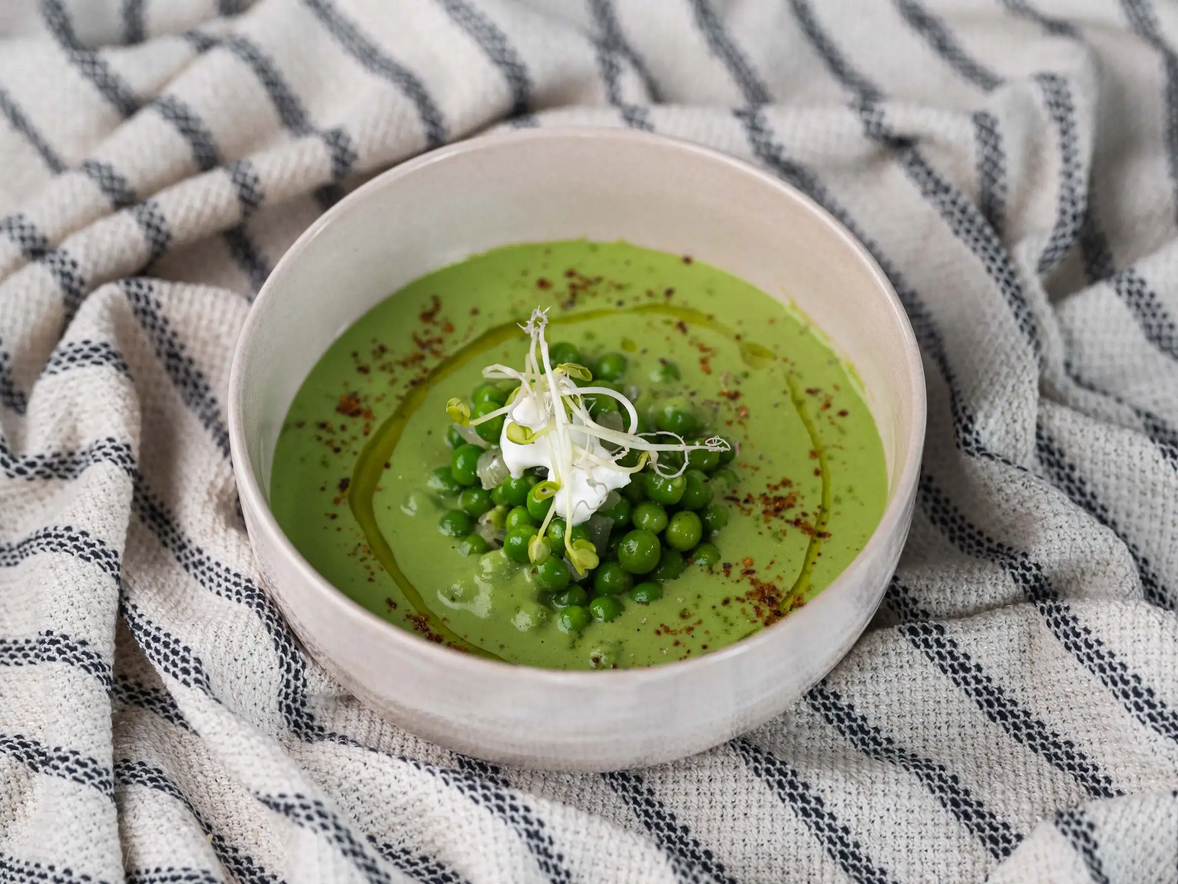 Velouté de petits pois frais servi dans un bol